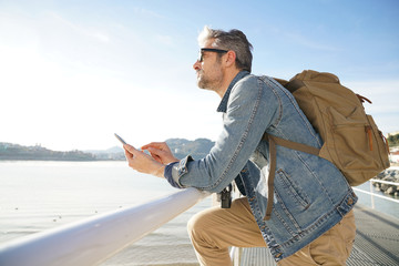 Man standing by the sea using smartphone, winter season