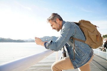 Man standing by the sea using smartphone, winter season