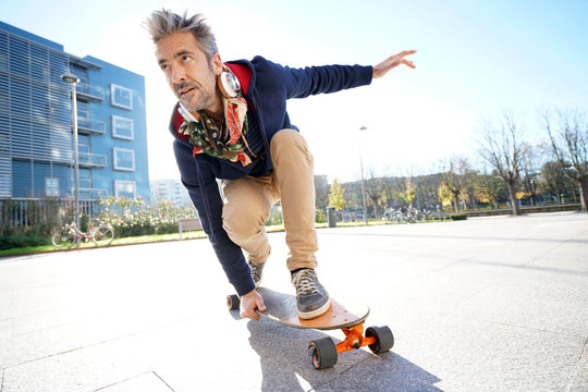 Mature man skateboarding in the street