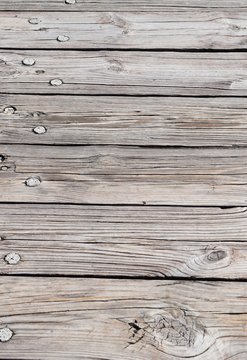 Alte, rissige, verblichene Holzplanken mit Holzn&auml;geln und Astloch in Nahaufnahme