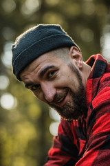 portrait of a man - lumberjack with an ax in the forest, side view