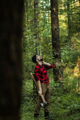 portrait of a man - lumberjack with an ax in the forest, side view