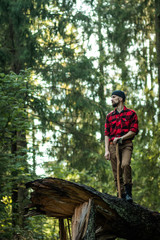 portrait of a man - lumberjack with an ax in the forest, side view