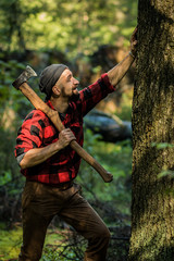 portrait of a man - lumberjack with an ax in the forest, side view