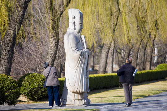 Elderly tourists look at statue of a high civil official, advisor to the emperor, on Spirit Way, Ming Tombs, Beijing, China