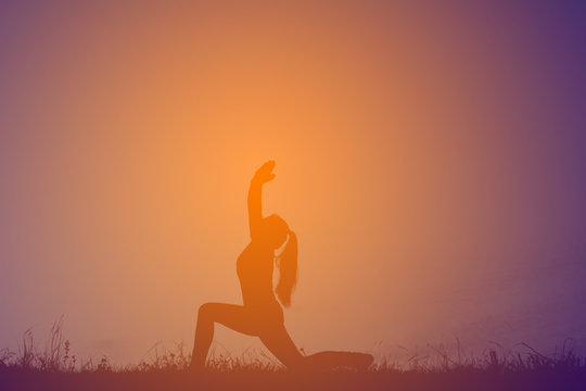 Silhouette women yoga in nature at the sky sunset, color of vintage tone
