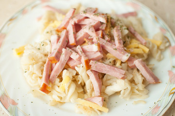 Pasta with bacon and cheese on big flat plate. Top view