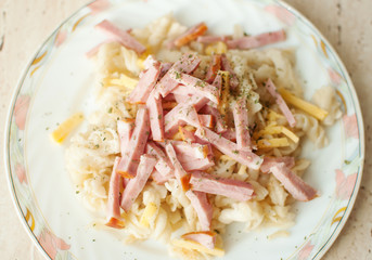 Pasta with bacon and cheese on big flat plate. Top view