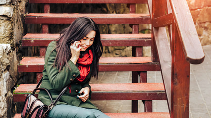 Long hair girl sitting on the stairs with phone