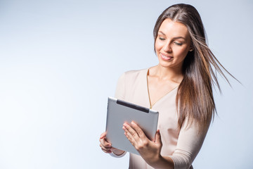Fototapeta premium Young brunette business woman working on a tablet computer