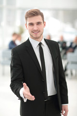 Portrait of a young handsome businessman offering a handshake