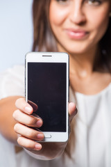 Pretty brunette business woman working on her smart phone planning business meetings or taking selfies.