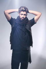 Portrait of young handsome fashionable man against wooden wall.