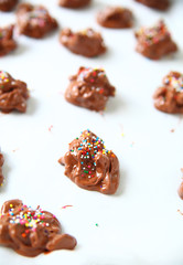 Chocolate candies with nuts and multicolored sprinkles on parchment paper