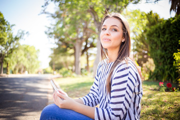 Young brunette business woman working / texting / talking  / taking a selfie on her smart phone while out and about in a suburban area