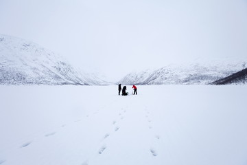 Ice fishing on frozen lake in the arctic alps in the Arctic Circle on Ringvassoya Island in the region of Tromso, Northern Norway