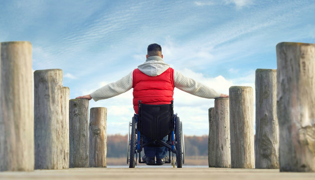 lebensfroher, entschlossener Mann im Rollstuhl am See