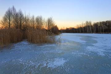 Sunset in the cold evening on the frozen lake.