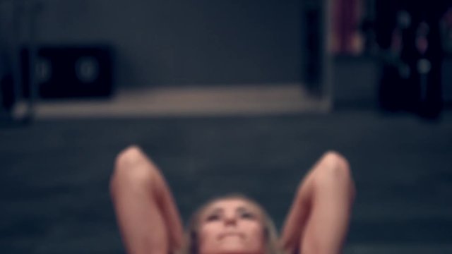 Muscular woman in a red top working out in the gym lifting weights