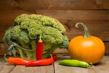 Fresh healthy useful vegetables broccoli, pumpkin, peppers on wooden table close up. 