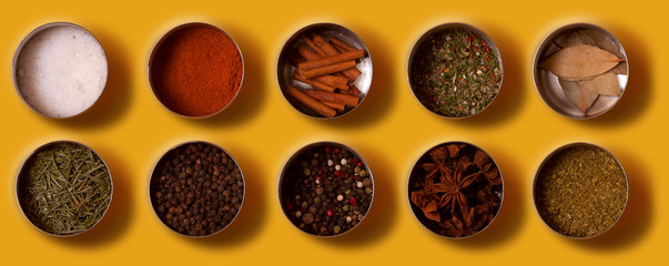 Bright set of spices Asian and South American cuisine in metal cans on yellow background