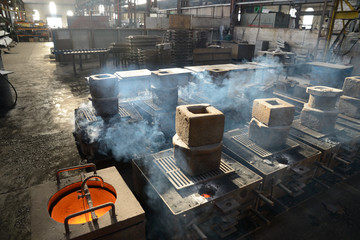 steam rises as cast iron cools in a foundry