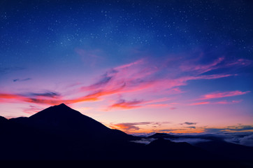 Silhouette of volcano del Teide against a sunset sky. Pico del Teide mountain in El Teide National park at night. Night landscape background with milky way on the sky. Tenerife, Canary Islands, Spain