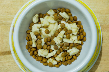 Dog food cereal mixed with banana in the bowl