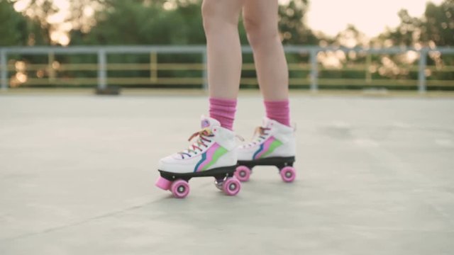 Female legs in roller blades skating at the playground