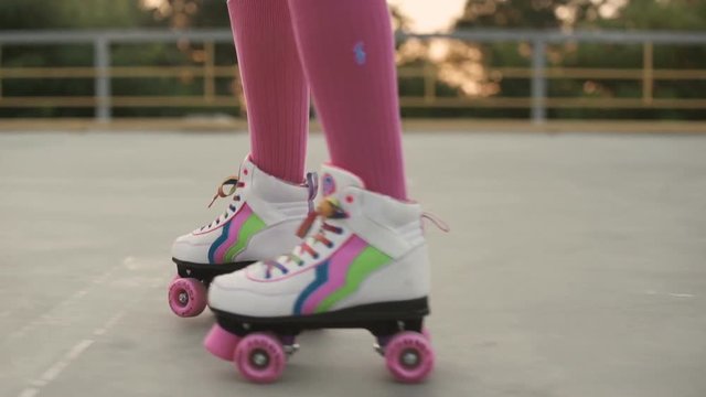 Female legs in roller blades skating at the playground