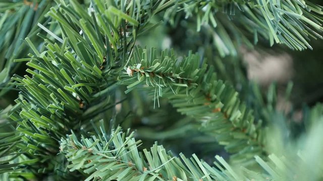 Realistic decorative spruce details slow tilt 4K 2160p 30fps UltraHD footage - Close-up of Christmas tree artificial branches with green needles 3840X2160 UHD tilting video 