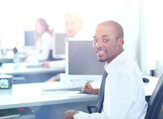 Obraz premium Portrait of a happy African American entrepreneur displaying computer laptop in office