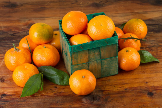 tangerine mandarin fruits in green box on old wooden table
