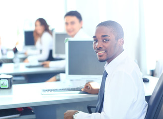 Fototapeta premium Portrait of a happy African American entrepreneur displaying computer laptop in office