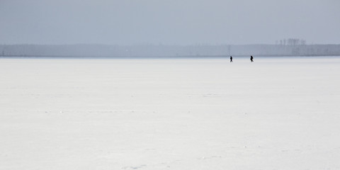 Ice on the lake in the winter, in Russia. Fishermen.