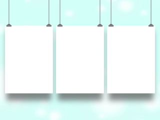 Three blank frames hanged by clips against aqua out of focus abstract background