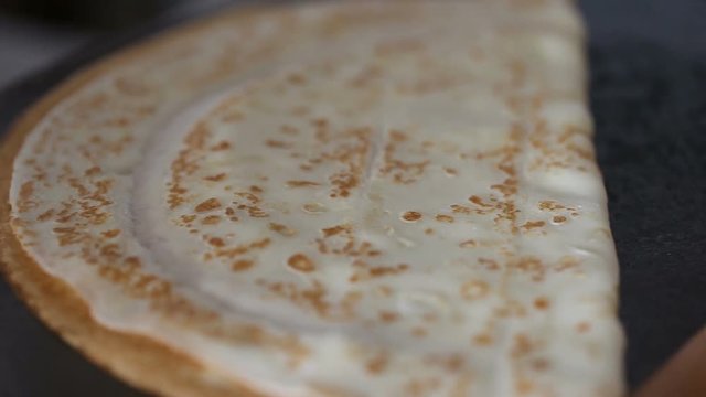 Chef folded pancake at pan after fry