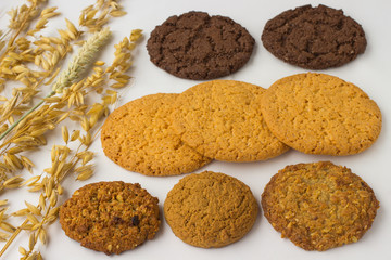 Different kinds of cookies and oat twigs on  white background