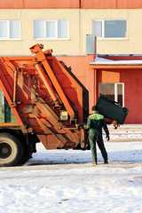 working loads rubbish bin at a recycling machine.
