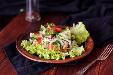 Тарелка с салатом из свежих овощей на деревянном столе, рустик