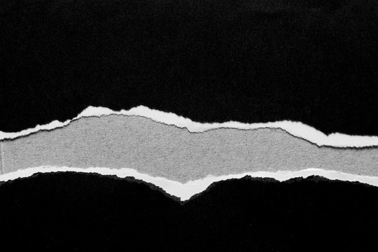 Ripped black paper on grey background