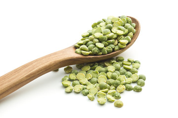Green split peas in wooden spoon.