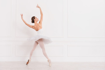 Graceful young girl holding her arms in the air