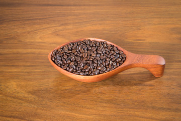 Coffee beans in wooden bowl on wooden background...