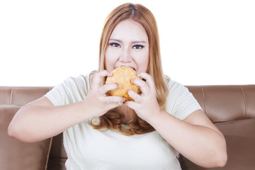 Greedy blonde woman eats hamburger