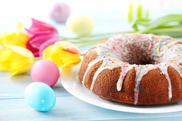 Easter eggs with cake on a blue wooden table