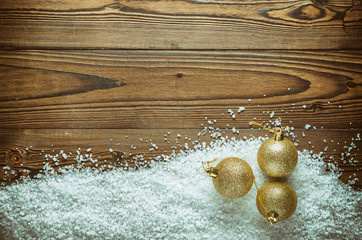 Christmas Background Theme. Gold Christmas Balls On The Snow (Large Sea Salt) On A Wooden Background. Close-Up. Vintage, Grunge Version. Top View.