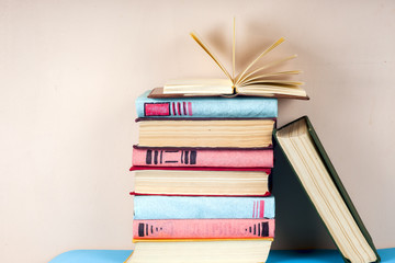 Open book, stack of colorful hardback books on light table. Back to school. Copy space for text