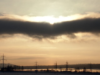 Fototapeta na wymiar Необычное темное облако в зимнем небе освещено солнцем