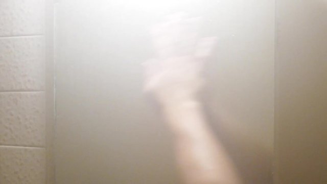 Hand Cleaning The Foggy Mirror In The Bathroom